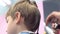 Hairdresser comb hairs with hairbrush and spray it with water. Back view, stylist\'s hands close-up.