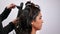 Hairdresser combing and curling a young girl`s hair