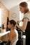 Hairdresser combing customer\'s hair