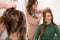 Hairdresser combing a haircut to young girl