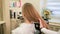 Hairdresser combs a girl`s hair in a beauty salon
