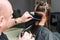 Hairdresser combs hair of woman