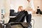 Hairdresser covered client with hairdressing gown