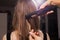 Hairdresser curling a hair strand of a woman