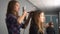 Hairdresser curling hair to brown hair girl in beauty salon