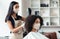 Hairdresser and customer wearing protective masks at beauty salon