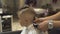 Hairdresser cutting children hair to little boy with electrical shaver in barber salon. Kids haircut with hair machine