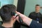 Hairdresser cutting hair male with hair clipper