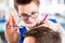 Hairdresser cutting man hair in barbershop