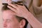 Hairdresser cutting senior man\'s hair