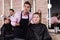 Hairdresser discussing female customer preferences in barbershop