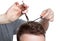 A hairdresser does a haircut for a young man in a barbershop