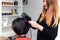 hairdresser doing hair styling to a woman in the salon, close-up