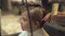 Hairdresser drying hair of little boy while children cutting in hairdressing salon. Close up barber blowing children
