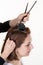 Hairdresser Female hairstylist hands cutting girl hair at salon