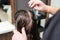 Hairdresser hand combing hair of woman