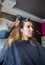 Hairdresser hands combing hair of beautiful young woman