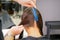 Hairdresser hands parting hair of woman