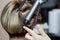 Hairdresser makes hairstyle girl with Brown hair in a beauty salon.