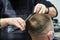 Hairdresser makes a mens haircut in a barbershop. Close up process