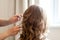 Hairdresser making curly haircut, beauty saloon