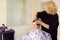 Hairdresser making hairstyle for middle age woman in beauty salon. Short haircut for women