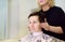 Hairdresser making hairstyle for middle age woman in beauty salon. Short haircut for women