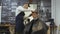 Hairdresser for men. Barbershop. A young guy gets a haircut and hair care service from a bearded man with a hair tied on