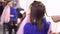 Hairdresser plaits braids with pink artificial strands with to a young woman