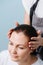 Hairdresser preparing client`s wet sleek brown hair for trimming