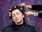 Hairdresser putting rollers in woman hair