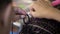Hairdresser`s female hands professionally braiding a pigtail with a hook close up. Braiding.