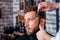 Hairdresser shaves man`s beard with a blade