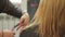 The hairdresser shears a woman with long blond hair. Haircut closeup