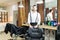 Hairdresser Smiling By Chair In Shop