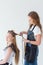 Hairdresser smooths the hair of a client with a curling iron