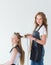 Hairdresser smooths the hair of a client with a curling iron