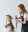 Hairdresser smooths the hair of a client with a curling iron