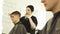 Hairdresser spraying water and combing wet hair before cutting. Male hairstyle in barber salon. Woman barber combing