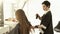 Hairdresser spraying water on long hair female haircut in hairdressing salon. Female hairstyle in beauty salon
