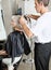 Hairdresser Straightening Female Client\'s Hair