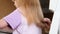 Hairdresser Trimming the Ends of a Blond Girls Hair. Mother doing daughter's haircut at home