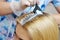 The hairdresser uses a brush to apply the dye to the hair, for d