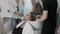 Hairdresser washes woman`s hair in the beauty studio.