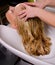 Hairdresser washing blond hair