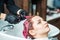 Hairdresser washing colored hair in pink