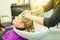 Hairdresser washing customer young woman meches head with professional shampoo and hair conditioner - People beauty care concept