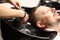 Hairdresser washing mans head in beauty salon