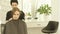 Hairdresser wearing cloack robe on young woman before haircut in hair studio. Preparing for haircut in hairdressing