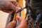 Hairdresser weaves braids with kanekalon material to young girl head, making creative hairstyle with thick plaits